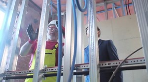 Builder and businessman check metal wall frame at construction site. Realtime.