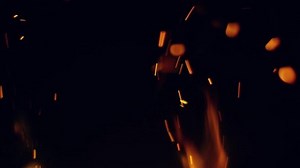 Burning red hot sparks rise from large fire in the night sky. Beautiful abstract background on the theme of fire, light and life.