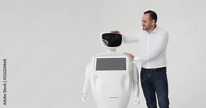 man stroking a robot. friendship with a robot. Modern Robotic Technologies. A man communicates with a robot,