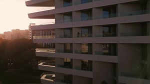 clip-3614487437-modern-high-rise-building-sunset-featuring-glass-balconies