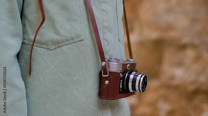 girl with a camera. A stylish girl with a film camera walks around the city. film camera close up. adventures and travel.