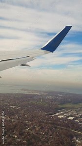Passenger jet wide shot wing view window seat perspective revealing the landscape trees forest sea water long island new york