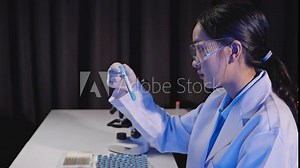 Scientist conducting experiments in a laboratory, examining test tubes, and preparing samples with microscopes and test equipment