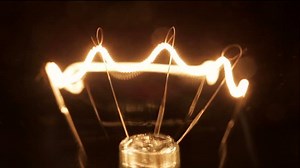 Close up light bulb. Filament gradually turns on and off