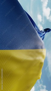 Wavy flag of Ukraine blowing in the wind in slow motion. Waving official Ukrainian flag team symbol abstract vertical background. Blue sky with clouds. World countries flying flags concept