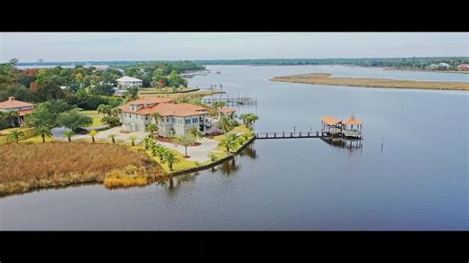 104 SPANISH POINT CIR • OCEAN SPRINGS • MS 39564 EXQUISITE WATERFRONT HOME THAT HAS EVERYTHING YOU COULD DREAM OF! This fully renovated stucco home with a metal roof, set on 2.1 acres of pristine bayfront land, offers deep water access and sweeping views, making it the perfect combination of luxury and functionality. Located just minutes from the Gulf of Mexico, the property features a boat house with a lift, ideal for boating enthusiasts. Inside, the home is bathed in natural light, with large 