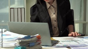 Young female accountant working on documents in the office, financial calculations, using a calculator, reading documents while working on accounting and analyzing financial budgets in the office.