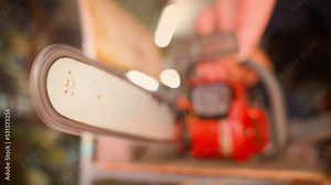 The chainsaw tire is pointed at the camera close-up. Rotating chainsaw chain on a blurred background. Dangerous behavior with industrial tools. The guy presses the accelerator on a non-petrol tool