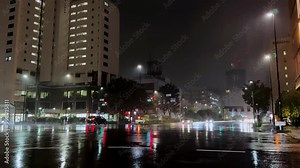 City intersection in Tokyo on a rainy night with reflections from traffic lights and wet streets