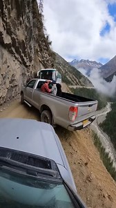 Tense Vehicle Bypass on Narrow Mountain Pass Karakoram Highway, Pakistan — May 4, 2024 Heart-pounding footage has emerged from the treacherous Karakoram Highway, capturing the moment a pickup truck and a passenger bus performed a high-stakes bypass on a crumbling cliffside ledge. The road, barely wide enough for a single vehicle, left the pickup truck’s rear tire hovering just inches from a sheer drop into the valley thousands of feet below. The video shows a silver pickup truck, carrying severa