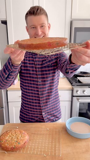 Slicing a thick cake layer into two thinner, even layers can be tricky. An easy way to guarantee even layers is to split the cake in the pan that you baked it in. For an 8” cake layer, I stacked 6” cake circles until they gave me enough height to raise the cake half way out of the pan. I wrapped the circles in plastic to form a ‘riser,’ and placed it in the pan before putting my chilled cake layer on top. Now the rim of the cake pan becomes a guide for my serrated knife, which cuts easily with a