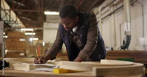 Carpenter, drawing and pencil with product design for construction, furniture or project. Black man, planning and wood with tools in a creative carpentry workshop for manufacturing, art and craft