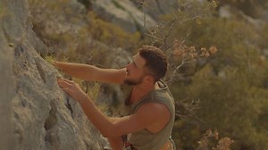 Concept of path to success and achievement of goal. Rock climber climbs rock high in mountains