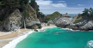 Coastal Waterfall Flowing onto Sandy Beach