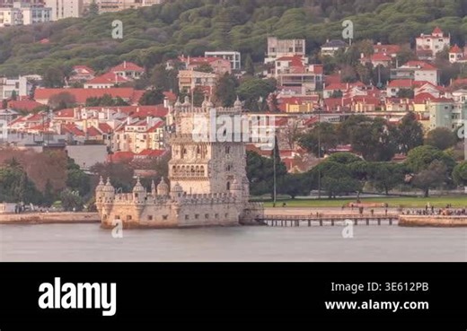 Aerial view of Belem Tower in Lisbon, Portugal, a famous UNESCO landmark by the Tagus River. Captivating sunset scene with people strolling the waterfront and lush park, blending history and beauty Stock Video Footage - Alamy