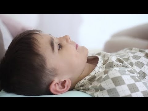 A Beautiful Girl Kisses a Young Child Who Lies on a Bed | Stock Footage - Videohive