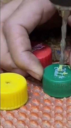 This is an easy and creative way to make a hole in a used bottle cap using a drill.