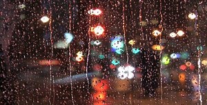 Rain Drops on Window with City Lights at Night