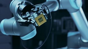 Modern High Tech Authentic Robot Arm Holding Contemporary Super Computer Processor Smoothly Moving into Focus. Industrial Robotic Manipulator End Effector Holding CPU Chip Moves Towards Camera Focus