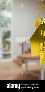 Animation of gold key and house key ring over blurred house interior. real estate, developer business and moving house concept digitally generated video.