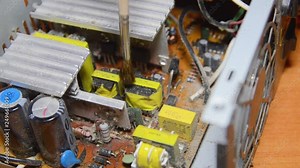 Cleaning your computer from dust. repairman cleans dusty parts. Computer power supply. macro. removes dust with a brush