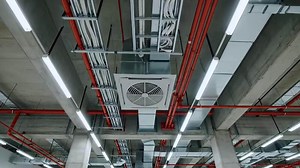 Download Industrial ceiling with exposed pipes, ductwork, and modern lighting in a commercial building for free
