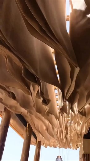 Parametric Architecture on Instagram: "📍Designed by Athens-based practice @k_studio_gr, this kinetic ceiling installation animates the beachside restaurant at Romanos Costa Navarino Resort through movement, lightness, and air. Dozens of suspended fabric banners respond to the coastal breeze, rippling in unison to create a living canopy above the dining space. Hovering over the tables, the inverted field of hanging textiles allows air to circulate while introducing a soft, rhythmic motion that e