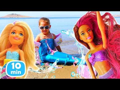 Selin and her mermaid dolls play on the beach