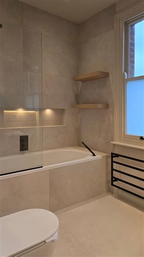 Original Bathrooms Richmond on Instagram: "A well-designed bathroom makes even the smallest space feel effortless. This compact layout shows how a 👉 walk-in shower, 👉 wall-hung toilet, 👉 and floating vanity can open up the room while keeping storage practical and maintenance simple. Warm brass fittings and neutral tiles add contrast without overwhelming the space, creating a bathroom design that feels calm, functional, and built for daily use. If you’re planning a bathroom renovation or redes