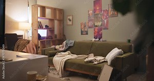 Messy, living room and couch in apartment, trash and food on floor, clothes and garbage on sofa. Lounge, home and house with rubbish, chaos and night after party, flat and rental and empty interior