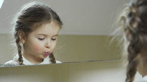 Little girl puts on lipstick in the mirror - Free Stock Video