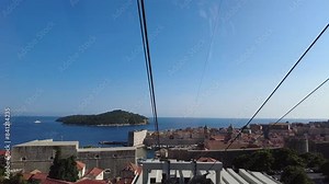 Moving cable car in Dubrovnik, Croatia. The footage presents the concept of an aerial journey, showcasing stunning views of the historic city and its beautiful coastal landscape.