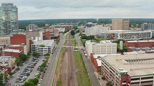 Downtown Durham North Carolina. Tracking shot above train tracks. Urban city in NC, USA.