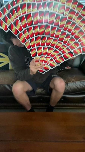 Person is holding so many Uno cards in his hand!