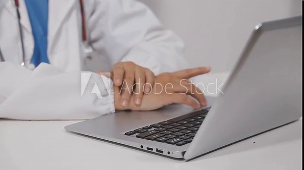 Female doctor working on laptop computer searching the information and using digital tablet at doctor's office. Medical student using computer, healthcare and medicine concept
