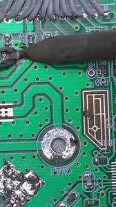 Hand holding soldering gun and working with lead repair board electronic on top view. Male hands close up soldering a microchip. soldering iron