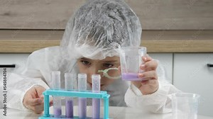A kid in a doctor's suit, a laboratory assistant conducts experiments in test tubes. The child studies reactions, childhood dreams. Biochemistry, bioengineering. Children in Science