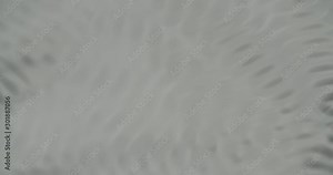 Water forming cymatic patterns and reflecting light. Physical phenomenon between frequency, vibration and liquid. Top shot of fluid surface under influence of acoustic frequency.