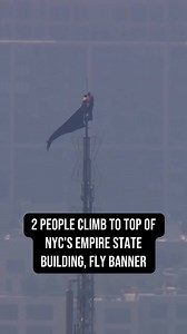 Two people could be seen with a banner at the very top of the Empire State Building in New York City Wednesday afternoon. The two, which appear to be a man and a woman, are wearing masks.