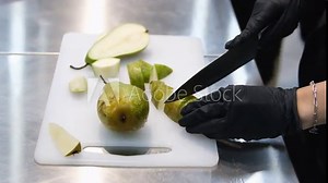 cut a pear Hands slicing a pear with a knife