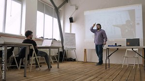 Lector explains subject to student Using language of gesture Theory for students Studying abroad School of cinematography Lecturing process Professor lectoring in classroom Student listening.