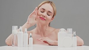 Skin Care, Woman advertises Set of different cosmetic white bottles of cream, serum, spray for skin care routine. Cosmetics packaging. Natural beauty product concept. Mock-up. Advertising, cosmetology