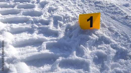 Close view of forensic marker near distinctive vehicle track pattern in winter setting