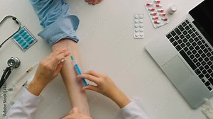 Female doctor making injection to the patient into the hand. Close-up. Top view.