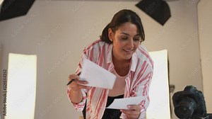 Female Photographer Editing Images From Photo Shoot In Studio