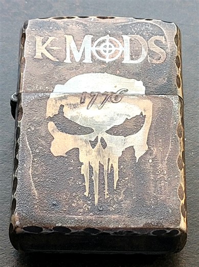 THE SHARPEST EDGE: K-MODS Armored Zippo This beautifully modified Zippo was created by Hans Klein of K-Mods. I fell in love with this zippo when I first saw the Punisher Skull... The Symbol my USMC family uses overseas. The rear has a WWI star that is on the Grave Marker of my Grandfather who served in the U.S. Cavalry during his honored servicebin the Army. The hobo coin reminds me of when my Grandmother would give hobos a meal, and food to take with them. They would either tie a ribbon or nail