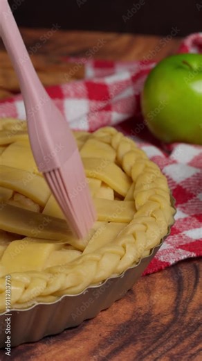 Vertical video, Preparing an apple pie, brushing the pie crust with an egg wash, green apple, macro view