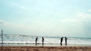 People on the beach at sunset. Walking, sitting and surfing Timelapse