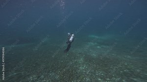Scuba diver swimming in the underwater currents of Komodo National Park, Indonesia