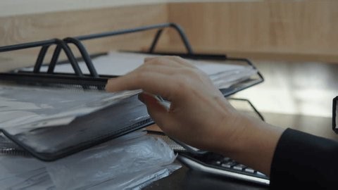 clip-4007498733-hand-searching-document-office-paper-tray